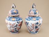 pair of blue and white vases with flowers on them on a beige background