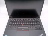 the laptop is open on a white surface with a red button on the keyboard