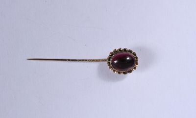 un gros plan d'une broche ornée d'une pierre rouge