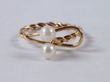 a close up of a gold ring with two pearls on it