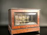 a glass case with a clock inside of it on a table