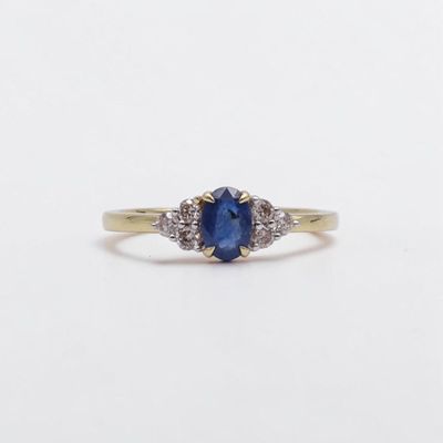 gros plan d'une bague avec un saphir bleu et des diamants