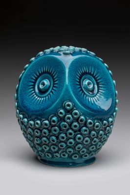 une photo d'une figurine de chouette bleue posée sur une table