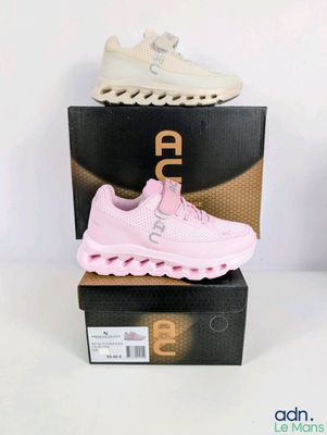 une paire de baskets roses posée sur une boîte