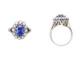 a close up of a ring with a sapphire and a diamond