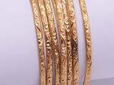 a close up of a stack of gold bracelets on top of a napkin