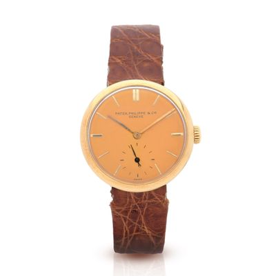 une image d'une montre-bracelet en or avec un bracelet en cuir marron