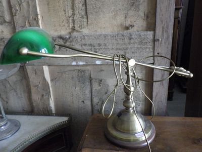 a green lamp that is on top of a wooden table