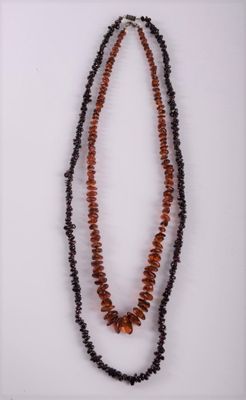 a close up of two necklaces with beads on a white surface