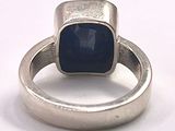 silver ring with a blue stone on top of it on a white surface