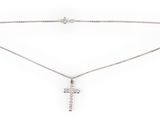 un collier avec une croix suspendue à une chaîne, sur fond blanc