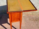a small wooden table with a glass top on a sidewalk