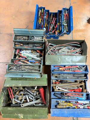 de nombreux outils de toutes sortes dans une boîte posée par terre