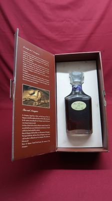 an open box with a bottle of liquor in it sitting on a red cloth