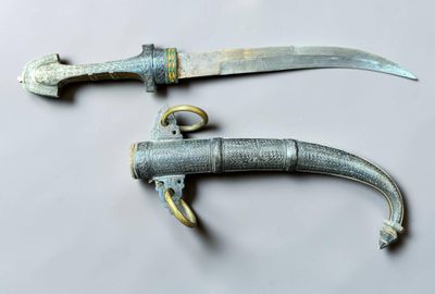 pair of old and rusty knifes on a white surface
