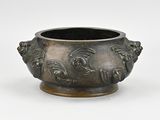 an image of a metal bowl with a face design on it