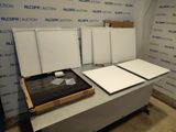 une table sur laquelle sont posés de nombreux tableaux blancs