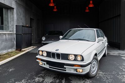 une voiture blanche garée dans un garage à côté d'une voiture noire