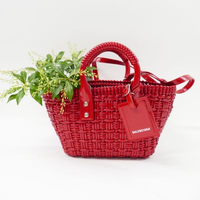 a small red basket bag with a plant in it