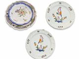 three plates with birds and flowers painted on them on a white surface