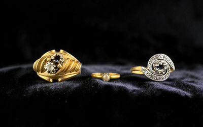 two gold and silver rings with diamonds on a black background