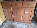 une armoire en bois comportant de nombreux tiroirs, surmontée d'autres tiroirs