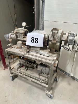 une machine qui se trouve dans un garage et sur laquelle est accrochée une pancarte
