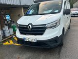 une camionnette blanche garée sur un parking à côté d'un bâtiment