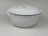 a white casserole with a lid on a white table