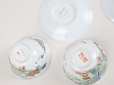 three chinese porcelain bowls and saucers on a white surface