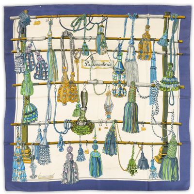 a close up of a blue and white scarf with tassels on it