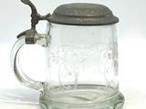 un mug en verre avec une anse posé sur une surface blanche