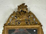 a mirror with a gold frame hanging on the wall