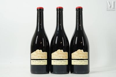 trois bouteilles de vin sont posées sur une surface blanche