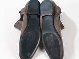 pair of men ' s shoes sitting on top of a bag on a white surface