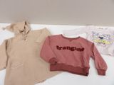 three children ' s sweaters are sitting on a white table