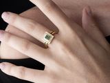 quelqu'un porte une bague sertie d'une pierre verte