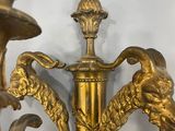 a gold colored candle holder with two birds on it