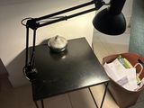 a black table with a lamp on it next to a blue couch