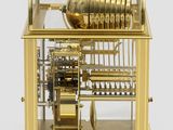a gold clock with a glass case on it