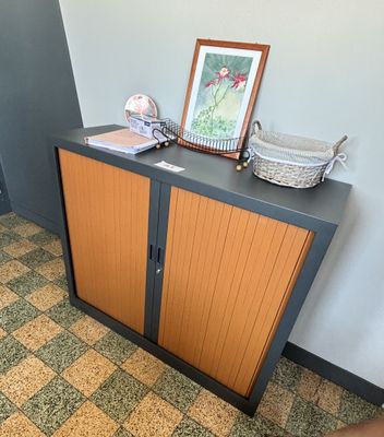une armoire sur laquelle est posé un tableau, dans une pièce