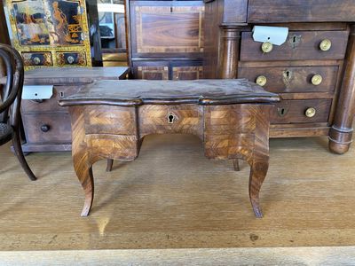 un bureau en bois muni de tiroirs, avec une chaise placée devant
