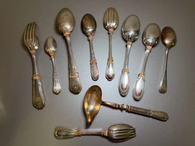 a lot of silver spoons and forks arranged in a circle