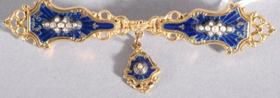 une broche bleue et dorée ornée d'un diamant en forme de goutte