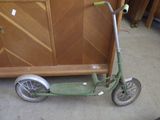 a scooter that is sitting on the floor in front of a cabinet