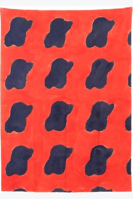 a red and blue rug with black spots on it