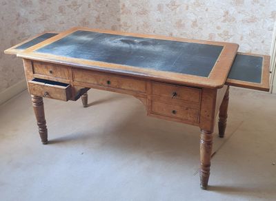 un bureau sur lequel se trouve un tableau noir, dans une pièce