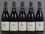 six bouteilles de vin sont alignées sur une table