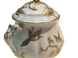 a white and gold teapot with a bird on it