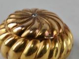 gold plated shell shaped object with a diamond in the center